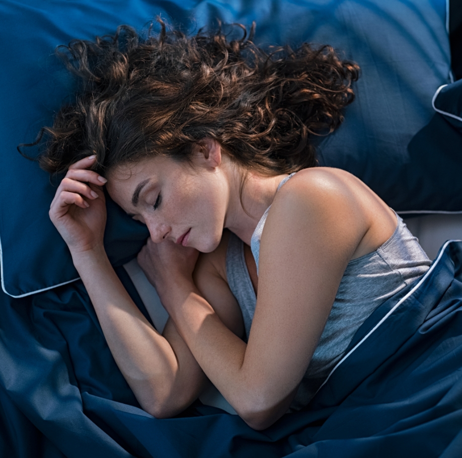 Frau liegt im Bett und schläft.